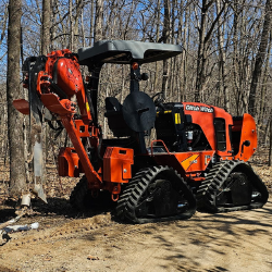 Ditch Witch heavy equipment underground utility contractors operating on a wooded job site