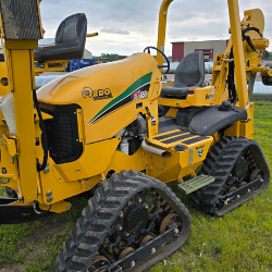 Vermeer compact utility trencher parked on a green job site